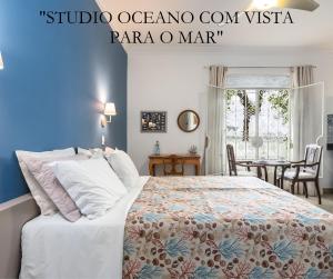 um quarto com uma cama grande e uma mesa em STUDIOS URCA na rua da mureta da Urca no Rio de Janeiro