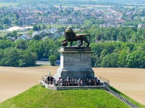 Un groupe de gens debout autour d'une statue de lion dans l'établissement Charleville 39 H Bruxelles-charleroi-aéroport, à Charleroi