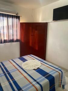 Zimmer mit einem Bett mit blauen und weißen Streifen in der Unterkunft Hotel brisas del mar 2022 in Catia La Mar