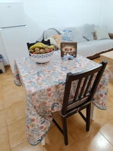 a table with a bowl of fruit and a chair at Garajonay in Puerto del Rosario