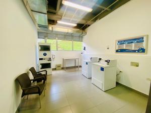 a large room with white appliances and chairs in it at Apartaestudio cercano al aeropuerto. in Rionegro