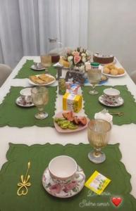 パラナグアにあるPousada Donatellaのテーブル(皿、グラス、食べ物付)