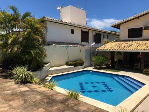 a swimming pool in front of a house at Vila Atlântica - House in Vilas do Atlântico in Lauro de Freitas