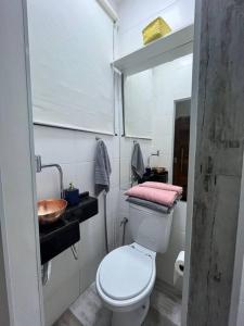 a bathroom with a white toilet and a sink at Apto Copacabana quadra da praia in Rio de Janeiro