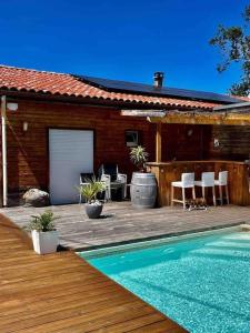 une maison avec une terrasse en bois et une piscine dans l'établissement Ma maison en bois avec Jacuzzi, à Lavelanet