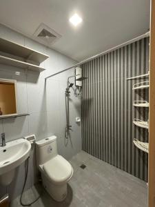 a bathroom with a toilet and a sink at The Cozy Casita in Manila