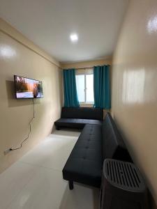 a living room with a couch and a tv at The Cozy Casita in Manila