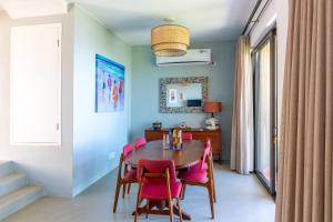 Mossel Bay的住宿－Cape St. Blaize，一间带桌子和粉红色椅子的用餐室