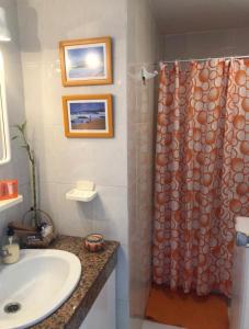 Un baño con lavabo y cortina de ducha. en Lido Playa Apartamento, en Cotillo