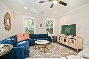 a living room with a blue couch and a tv at Mt Pleasant Beach Retreat- Mins to Sullivan's IOP in Charleston