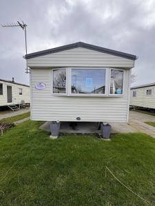 a tiny house is sitting in a yard at 3 bedroom pet friendly Lyons Winkups Towyn in Abergele