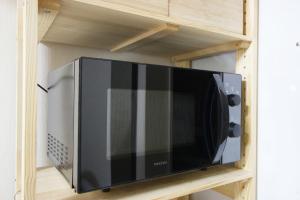 a microwave oven on a shelf in a kitchen at Kaku Studio Apartment Ikebukuro in Tokyo