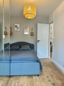 een slaapkamer met een blauw bed en een witte deur bij Le Chardon- appartement 2chambres- avec stationnement in Nancy