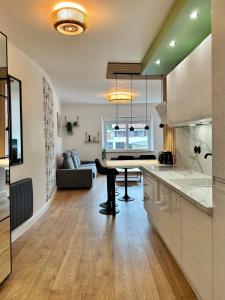 a kitchen with a table and a living room at Le Chardon Nancy- 2 chambres- parking gratuit- proche transports et Zénith in Nancy