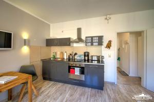 a kitchen with a stove top oven next to a table at Auszeit-im-Harz Haus 1 Wohnung Hexenstübchen in Schierke