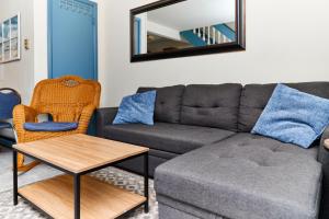 a living room with a couch and a mirror at Lighthouse Villa @ The Reef in Chincoteague