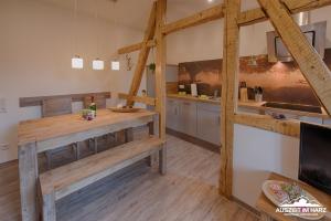 uma cozinha com uma mesa de madeira e uma televisão em Auszeit-im-Harz Haus 2 Wohnung 1 em Schierke