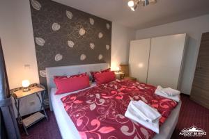 um quarto com uma grande cama vermelha com almofadas vermelhas em Auszeit-im-Harz Haus 6 Wohnung 2 em Wernigerode