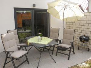 uma mesa de pátio com cadeiras e um guarda-sol em Auszeit-im-Harz Haus 6 Wohnung 2 em Wernigerode