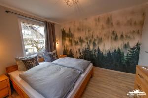 1 dormitorio con 1 cama con una pintura en la pared en Auszeit-im-Harz Haus 3 Wohnung 5, en Braunlage