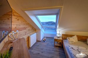 een zolderkamer met een bed en een raam bij Auszeit-im-Harz Haus 3 Wohnung 8 in Braunlage