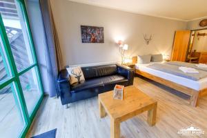 um quarto de hotel com uma cama e um sofá em Auszeit-im-Harz Haus 5 Wohnung 11 em Stiege