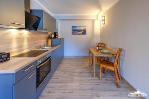 a kitchen with a wooden table and a table and a dining room at Auszeit-im-Harz Haus 5 Wohnung 23 in Stiege +12 photos