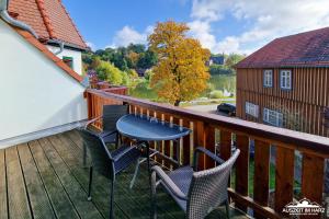 Un patio con sillas y una mesa en una terraza. en Auszeit-im-Harz Haus 5 Wohnung 33, en Stiege