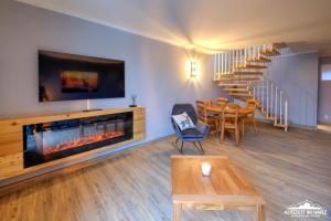 a living room with a fireplace and a dining room at Auszeit-im-Harz Haus 5 Wohnung 37 in Stiege