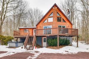 a large wooden house with a deck in the snow at Hot Tub and Fire Pit Lakefront Cabin in White Haven in White Haven