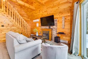 sala de estar con 2 sillas y chimenea en Lakefront Cabin with Hot Tub 6 Mi to Ski Resort! en White Haven