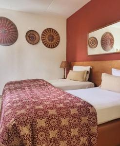 a hotel room with two beds and a mirror at Hotel Le Marly in Abidjan