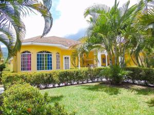 a yellow house with palm trees in front of it at A little piece of paradise! in Juticalpa