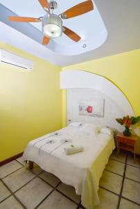 sypialnia z wentylatorem sufitowym i łóżkiem w obiekcie HOTEL LA RIVIERA w mieście Sabalito