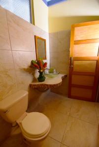 W łazience znajduje się toaleta, lustro i umywalka. w obiekcie HOTEL LA RIVIERA w mieście Sabalito