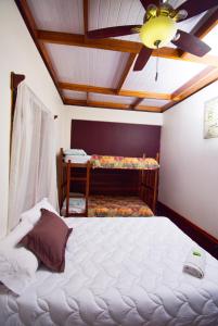 1 dormitorio con 1 cama y ventilador de techo en HOTEL LA RIVIERA, en Sabalito