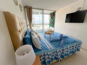 sala de estar con sofá azul y ventana en Con vista al mar en San Miguel, en Lima