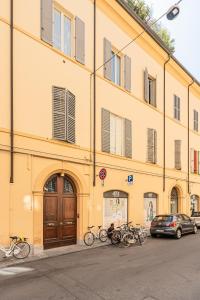 a yellow building with bikes parked in front of it at Molinari House Modena Centro Lux in Modena