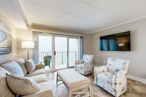 sala de estar con sofá, sillas y TV en Marigot Beach 1205 en Ocean City