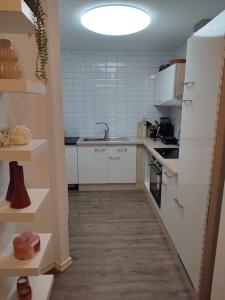 Elle comprend une petite cuisine avec des placards blancs et un évier. dans l'établissement Göteborgs Pärla nr 2, à Göteborg