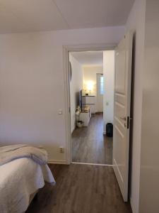 a white bedroom with a bed and a hallway at Göteborgs Pärla nr 2 in Gothenburg