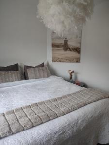 - une chambre dotée d'un lit blanc avec une photo sur le mur dans l'établissement Göteborgs Pärla nr 2, à Göteborg