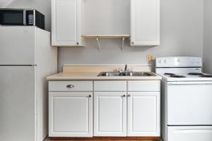 a kitchen with white cabinets and a sink at Flamingo Villa @ The Reef in Chincoteague