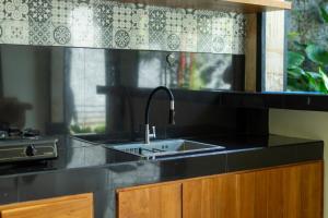 a kitchen counter with a sink and a window at Pondok Aruna in Ubud