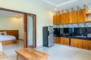 a kitchen with a refrigerator and a bed in a room at Pondok Aruna in Ubud