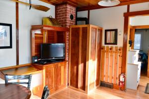 a living room with a tv on a wooden cabinet at Banff Beaver Cabins in Banff