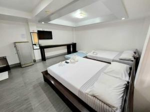 Habitación con 2 camas y TV. en MGG CASA DELA PLAYA en Boracay