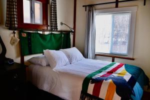 Banff Beaver Cabins في بانف: غرفة نوم بسرير ونافذة
