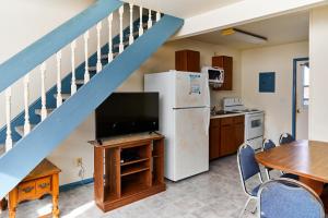 a kitchen with a refrigerator and a table with chairs at Shipwreck Villa @ The Reef in Chincoteague
