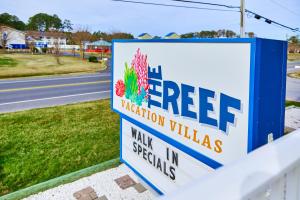 a sign for a tree vacation villas on the side of a road at Shipwreck Villa @ The Reef in Chincoteague